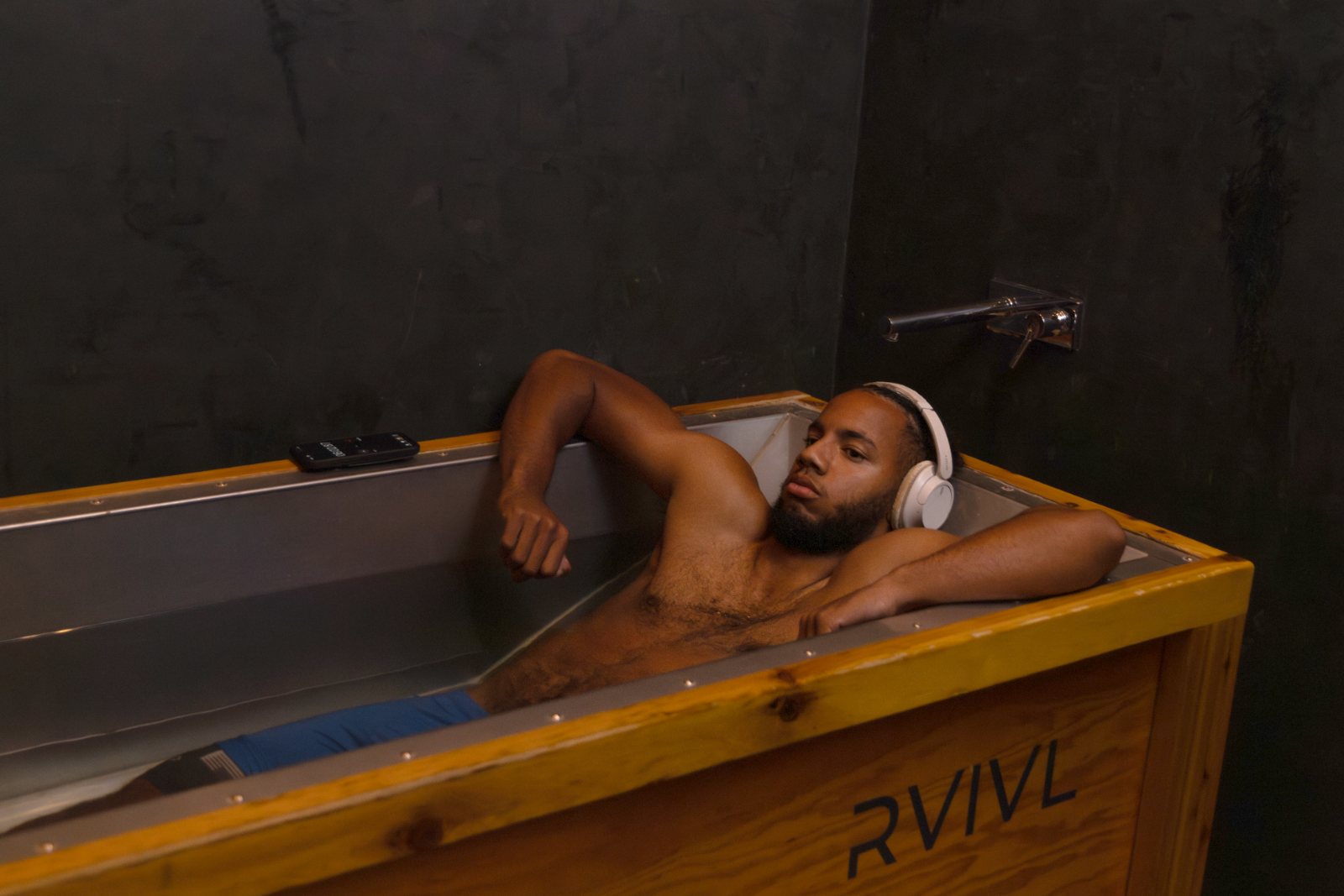 Guest with headphones on in the RVIVL ice bath