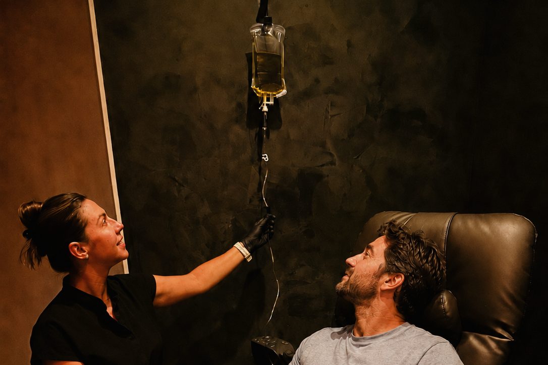 RVIVL staff setting up an IV drip for a guest in the lounge