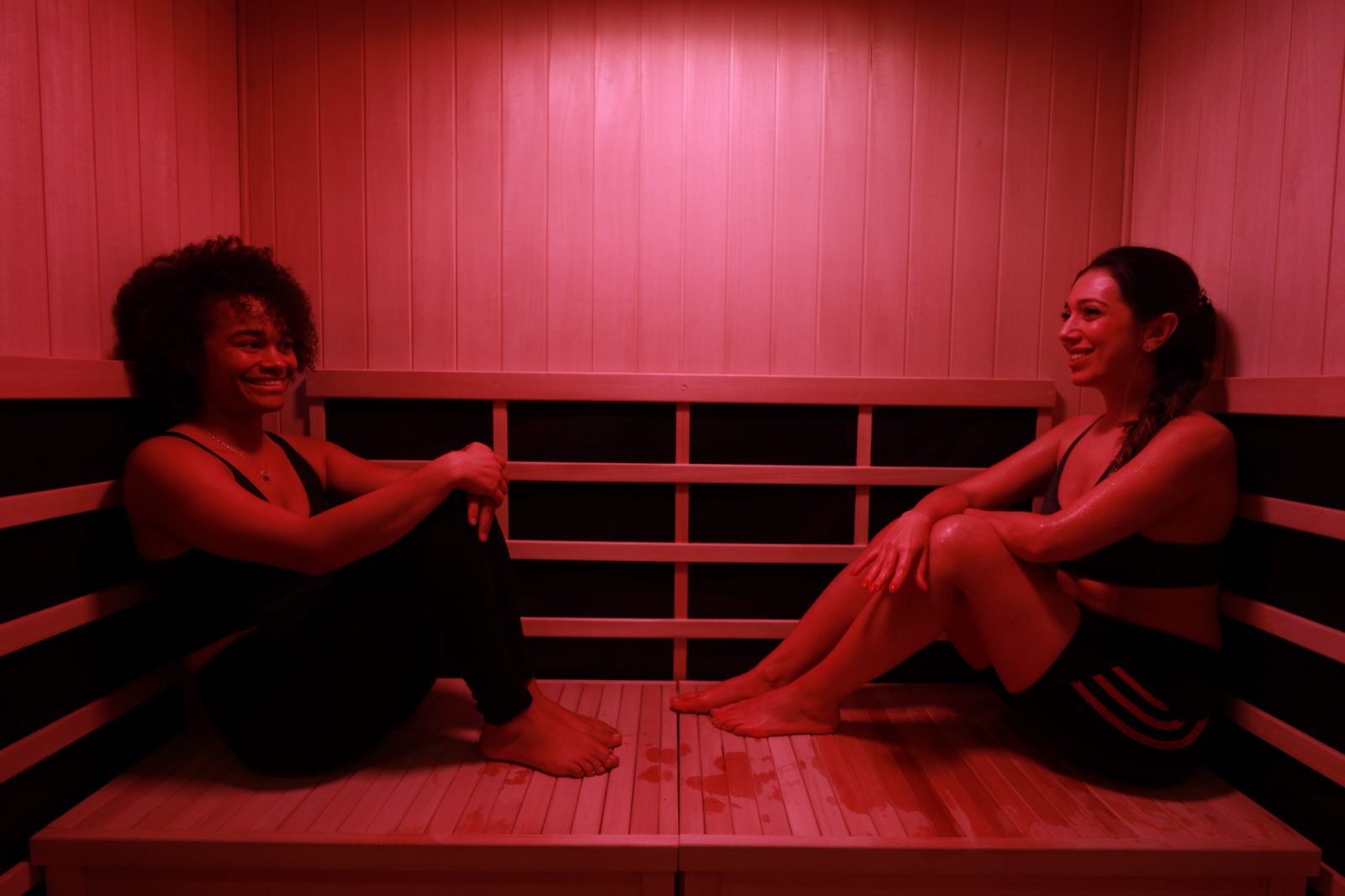 Two guests talking on the bench of an RVIVL infrared sauna