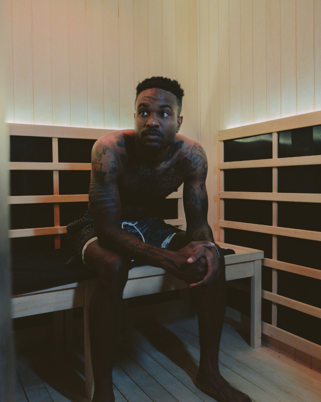 Guest seated on the bench in the infrared sauna cabin